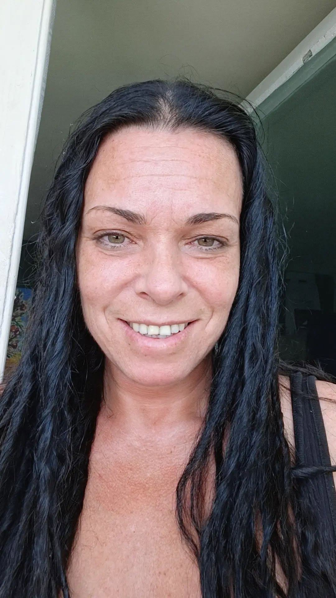Dana Marijuana făc&acirc;ndu-și un selfie &icirc;ntr-un maiou negru, cu părul desfăcut care &icirc;i at&acirc;rnă peste umeri