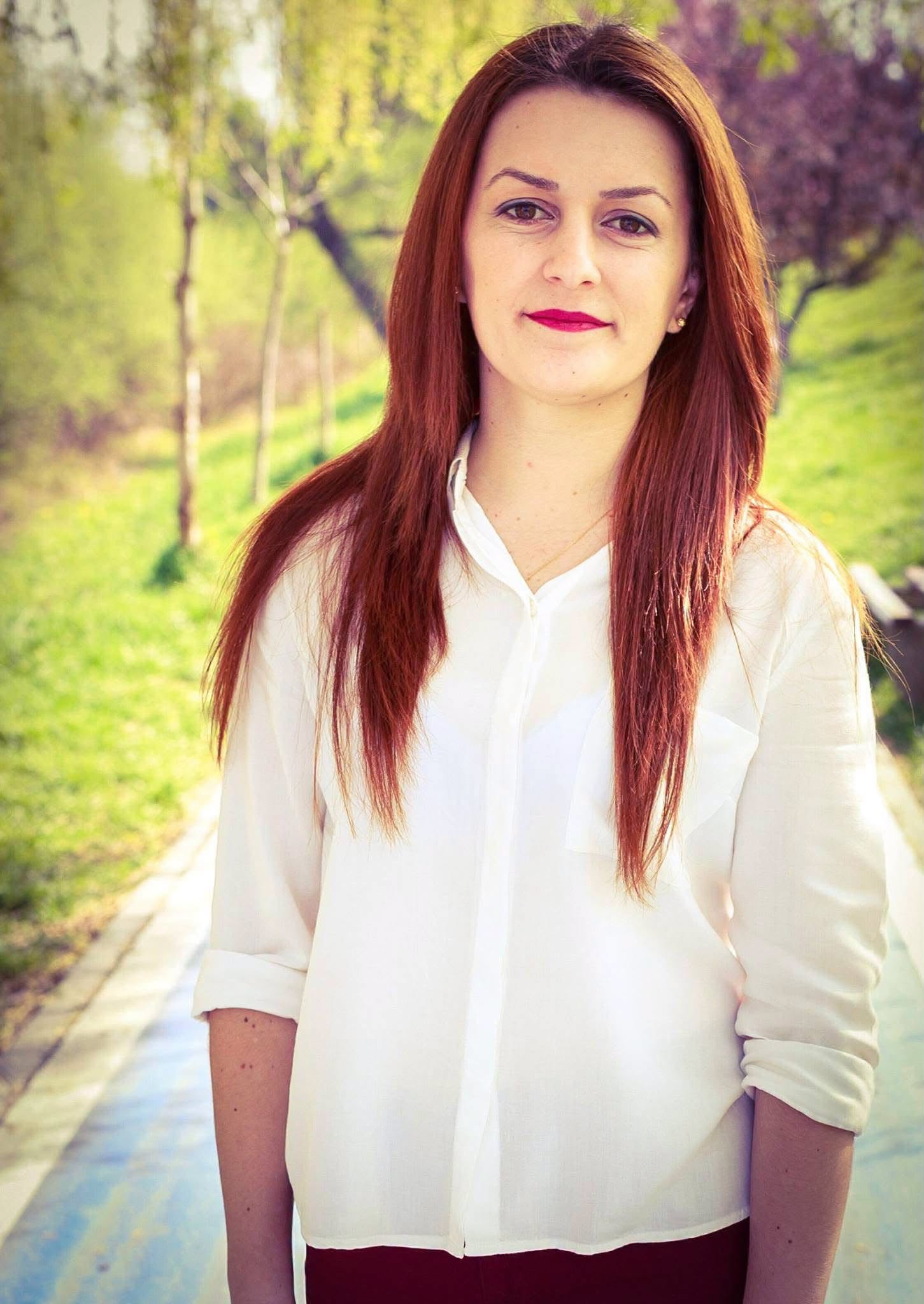 Laura Paicu &icirc;ntr-o cămașă albă, cu m&acirc;necile suflecate, cu părul vospit &icirc;ntr-o nuanță de roșcat