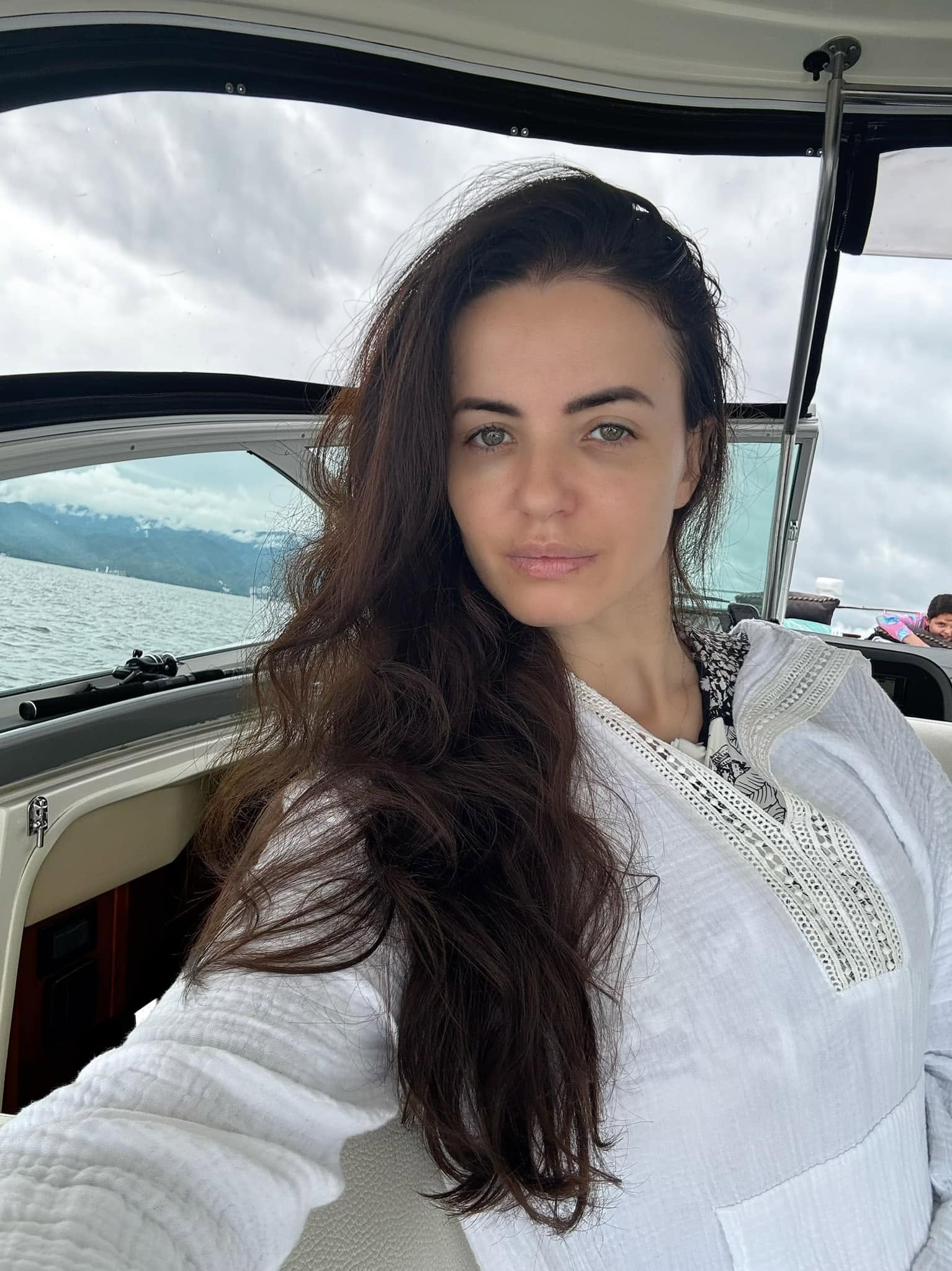Mădălina Apostol pe o barcă, &icirc;ntr-o bluză albă, cu părul &icirc;n v&acirc;nt