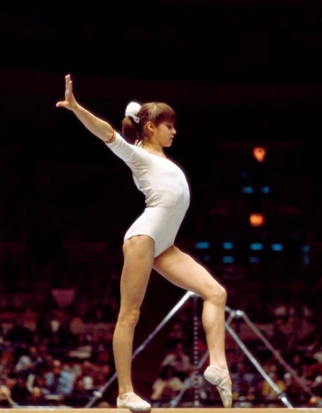 Nadia Comăneci la Jocurile Olimpice, &icirc;n adolescență, &icirc;mbrăcată &icirc;n costumul de gimnastică, &icirc;n timpul unei probe