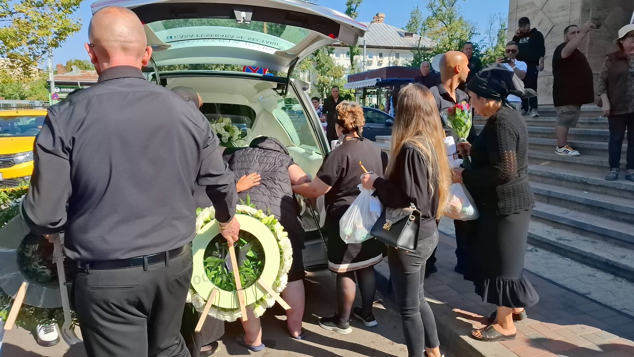 Apropiații în jurul sicriului Mădălinei Apostol care se afla în mașina care a transportat-o la cimitir