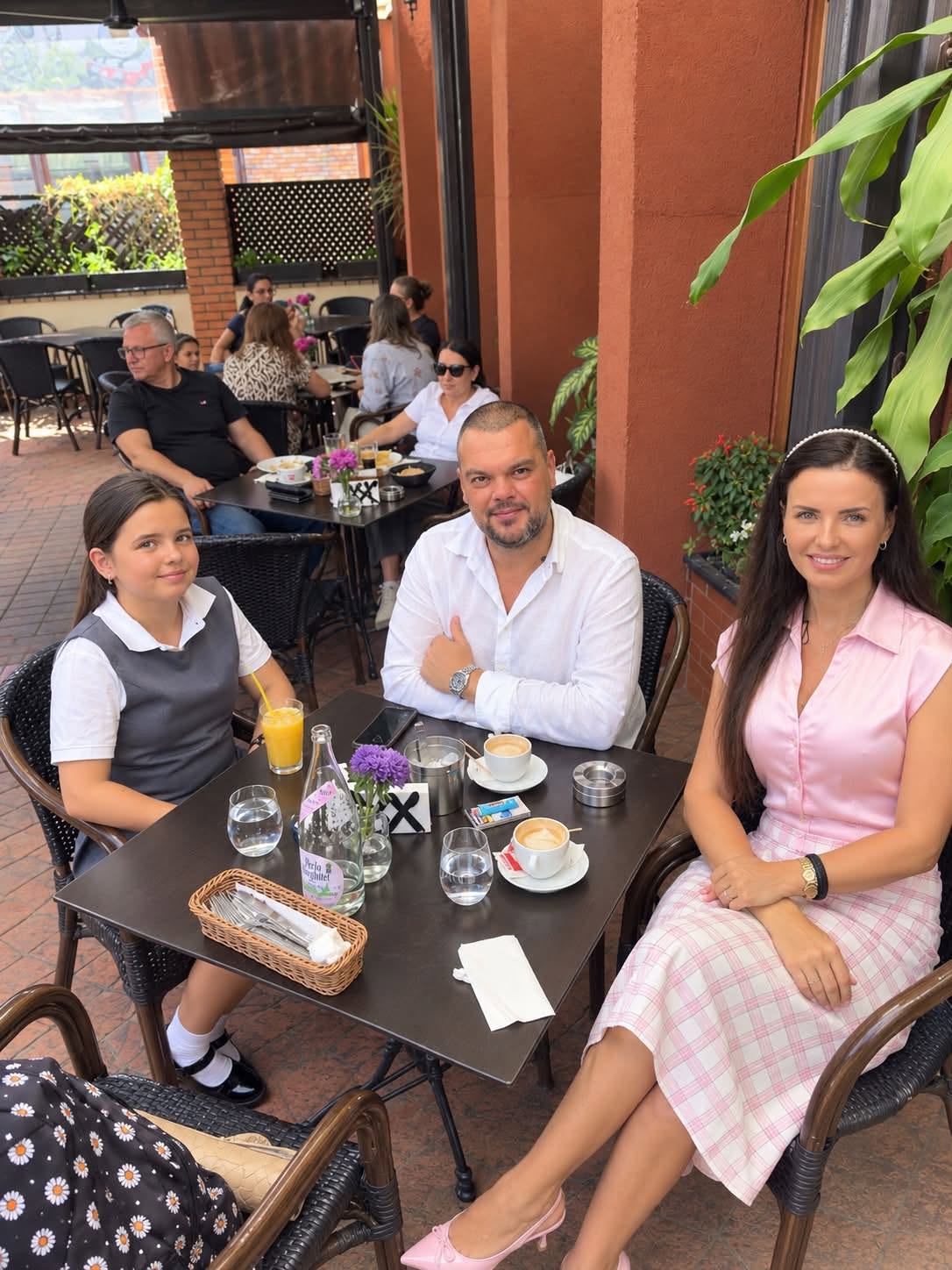 Mădălina Apostol alături de fiica ei și de tatăl acesteia, cu c&acirc;teva zile &icirc;nainte să moară, st&acirc;nd toți trei la aceeași masă z&acirc;mbitori, &icirc;mbrăcați elegant, pentru prima zi de școală a copilei