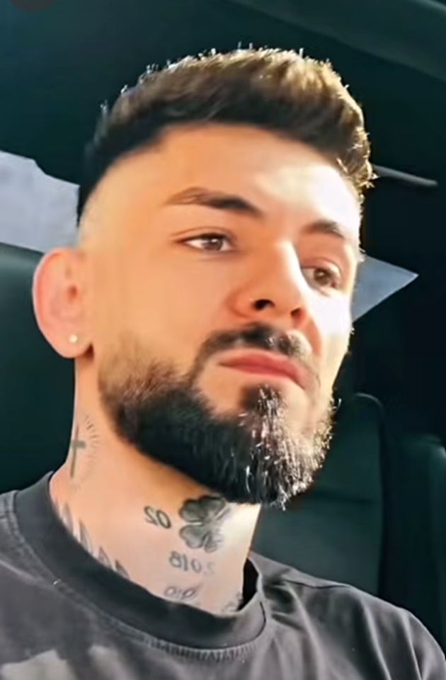 Vlad Bălțățeanu &icirc;n mașină, &icirc;mbrăcat &icirc;ntr-un tricou negru, cu tatuajele de pe g&acirc;t la vedere