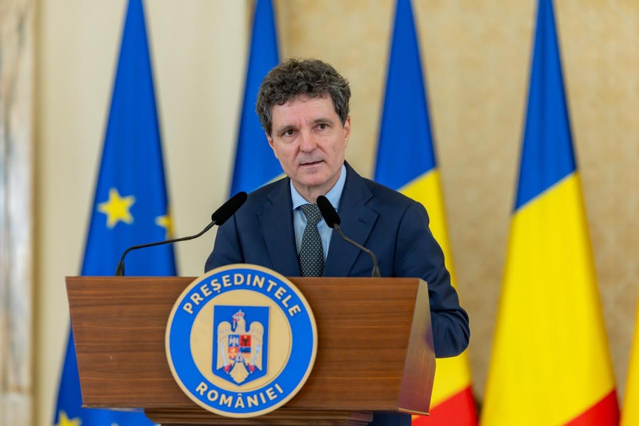 Președintele Nicușor Dan &icirc;n costum bleumarin, cămașă bleu și cravată cu picățele, st&acirc;nd la pupitru și vorbind &icirc;n fața colegilor politicieni