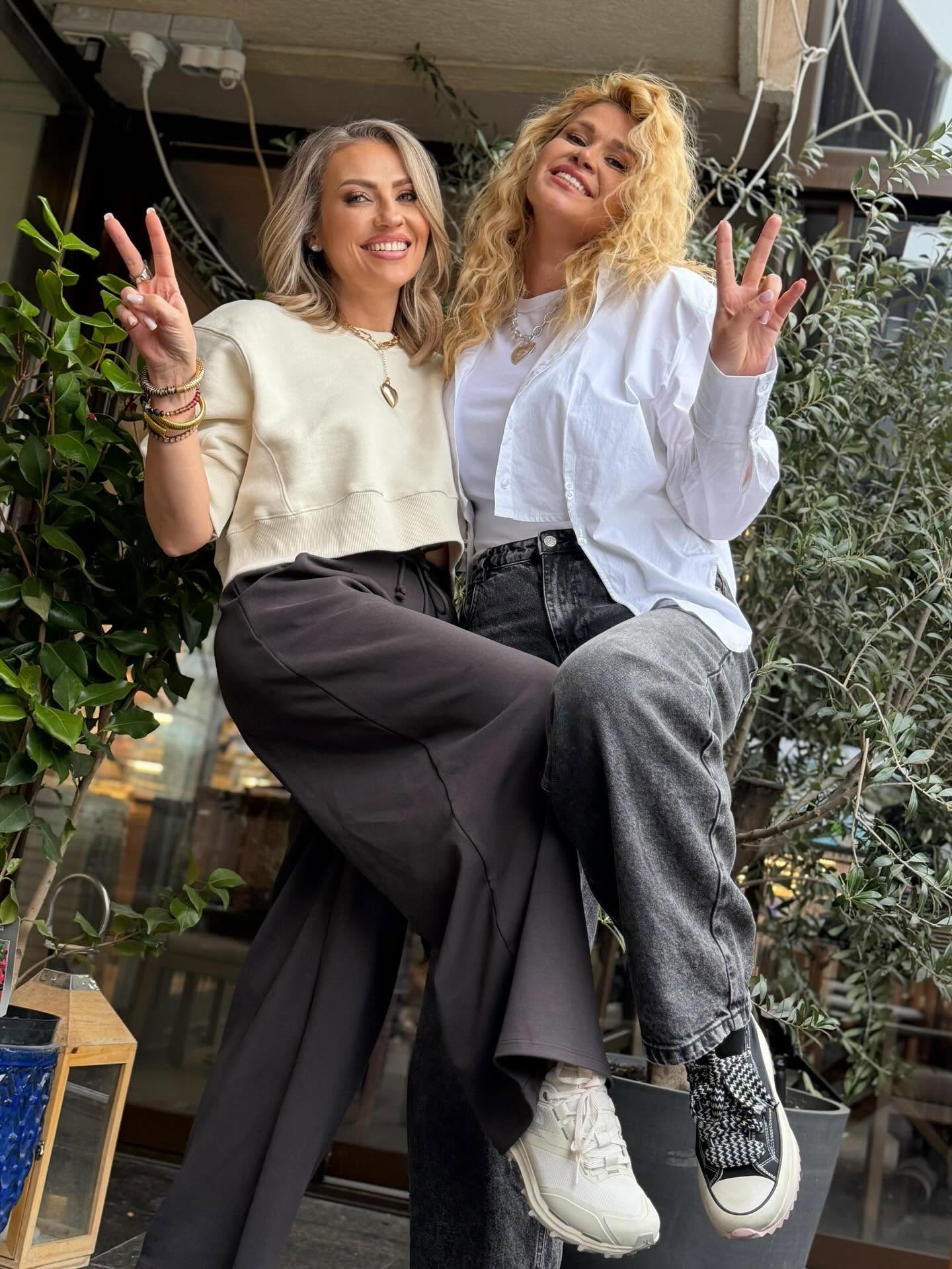 Mirela Vaida alături de Oana Tomoiagă, coechipiera sa de la Asia Express, st&acirc;nd am&acirc;ndouă pe o terasă plină cu flori, &icirc;mbrăcate lejer și z&acirc;mbitoare