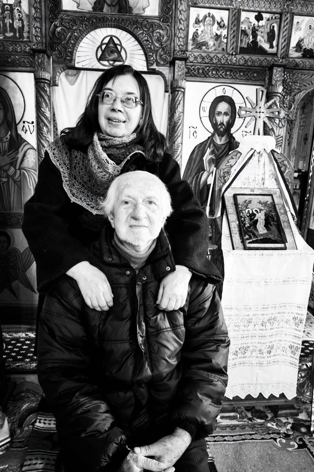 Imagine alb-negru cu Mihaela Grădinariu cuprinz&acirc;ndu-l &icirc;n brațe pe tatăl ei, Ioan Țicalo, care stătea pe un scaun &icirc;n biserică, &icirc;n fața altarului