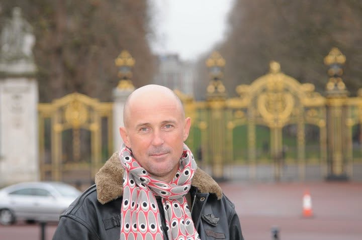 Mugur Mihăescu &icirc;mbrăcat pentru sezonul rece, &icirc;ntr-o geacă de piele, cu guler de blană, purt&acirc;nd la g&acirc;t o eșarfă cu imprimeu colorat