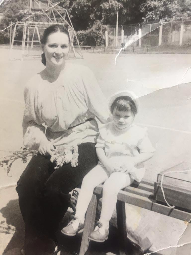 Imagine alb-negru cu Laura Cosoi &icirc;n copilărie, &icirc;mbrăcaă &icirc;n rochie albă, alături de mama ei, &icirc;mbrăcată &icirc;n alb și negru, care ținea un buchet de flori &icirc;n m&acirc;nă