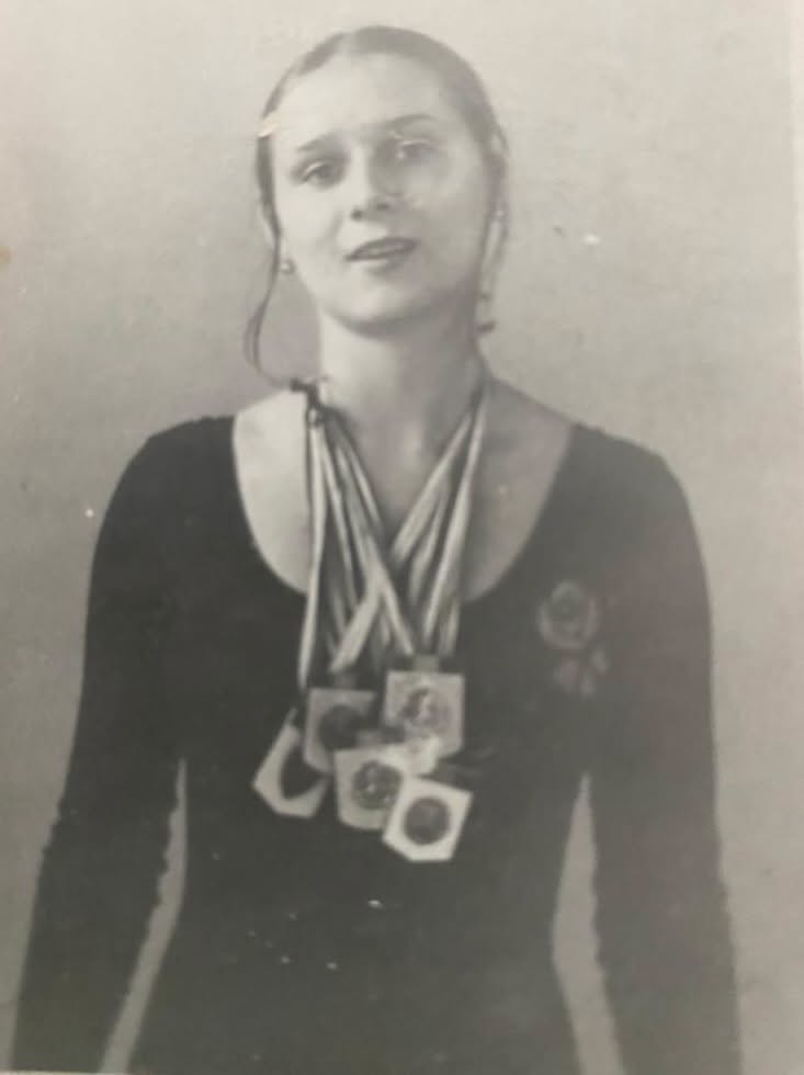 Ligia Cosoi, mama Laurei Cosoi, &icirc;n costum de gimnastică, purt&acirc;nd la g&acirc;t mai multe medalii c&acirc;știgate &icirc;n cariera sa