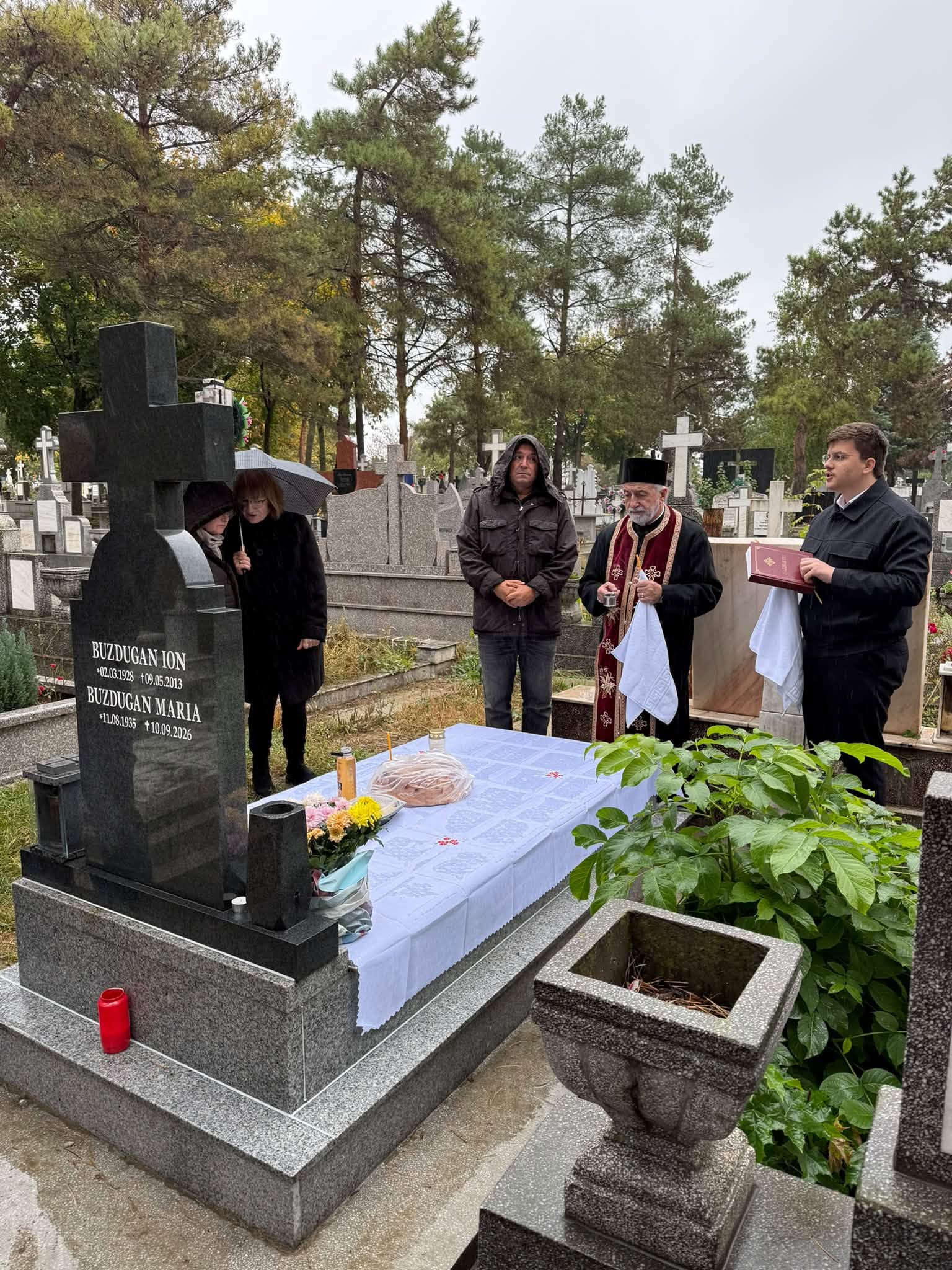 Daniel Buzdugan stând în ploaie în cimitir, înconjurat de oamenii care au participat la parastasul mamei sale, într-o zi de toamnă