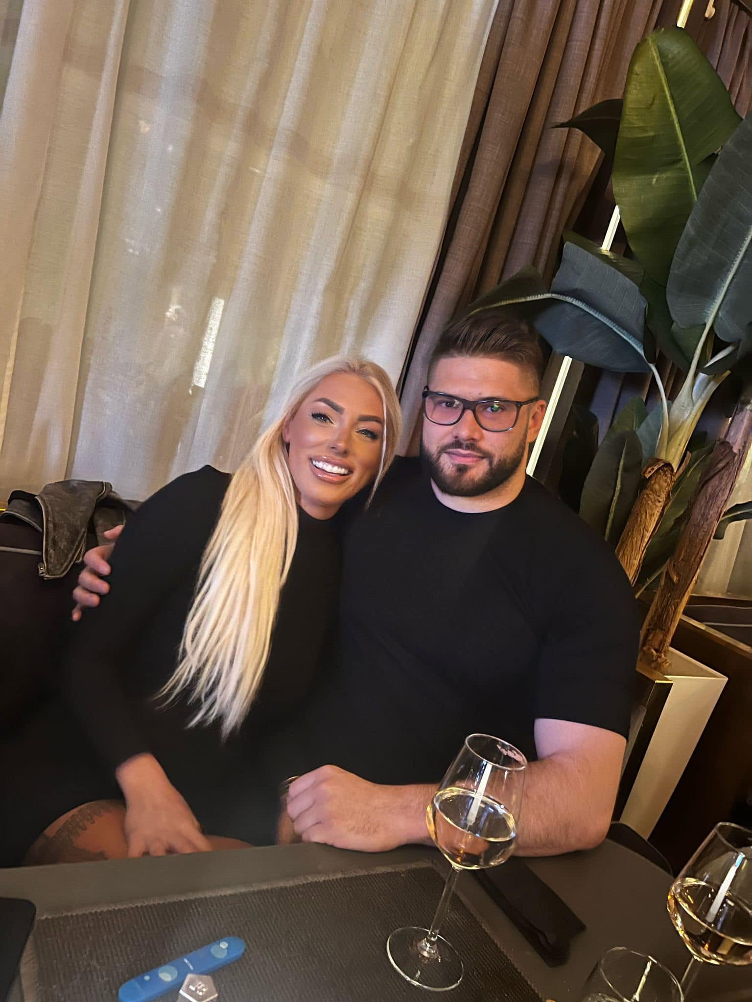Alin Alexuc alături de logodnica sa Antonia, pe care o ține &icirc;n brațe &icirc;n timp ce stau am&acirc;ndoi la aceeași masă, cu niște pahare de vin alb &icirc;n față