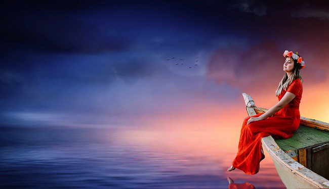 Femeie in rochie rosie, stand pe o barca, pe mare