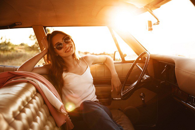 femeie cu ochelari de soare, stand la volan, in masina