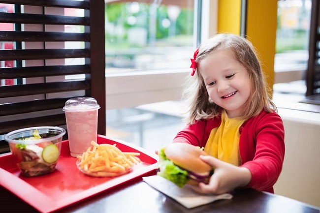 copil care mananca fast food