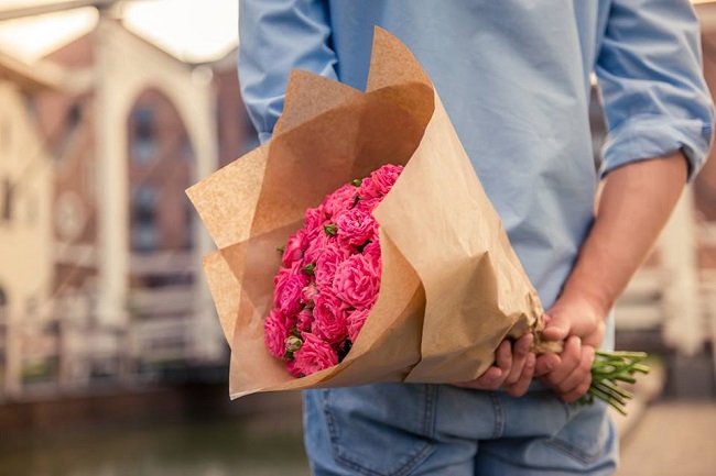 barbat cu buchet de flori roz