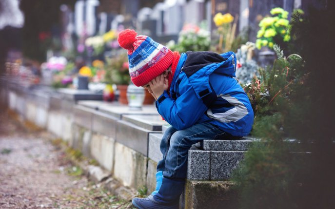 Un băiat vizitează mormântul mamei cu un buchet din florile ei preferate, un străin apare lângă el cu aceleași flori